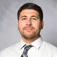 Headshot of Alejandro Gallegos, Assistant Professor at New Mexico State University, wearing a white dress shirt and a black and white patterned tie.