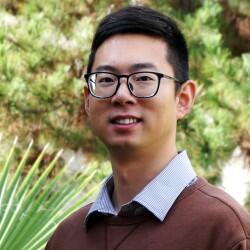 Headshot of Bosen Jin, a recent BCOE Graduate at UCR, wearing a brown sweater over a collared shirt.
