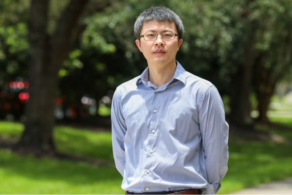 Portrait of Fudong Liu, Professor in the Department of Chemical and Environmental Engineering at UC Riverside, standing outdoors wearing a button-down shirt and glasses.