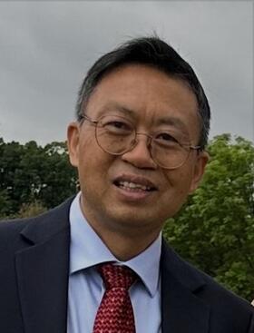 Headshot of Jianzhong Wu, Professor in the Department of Chemical and Environmental Engineering at UC Riverside, smiling and wearing a suit and tie outdoors.